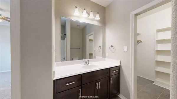 a bathroom with a sink vanity and a mirror