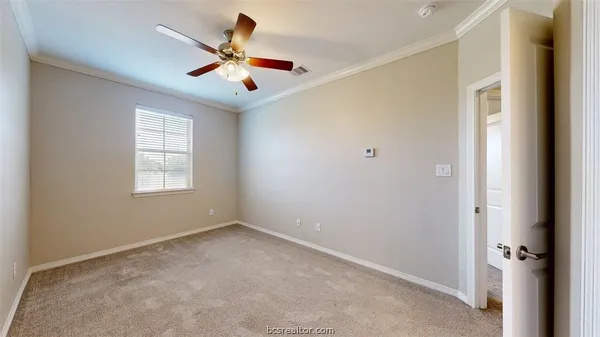 an empty room with ceiling fan and window