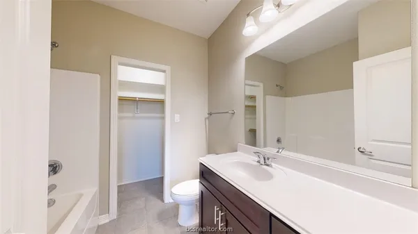 a bathroom with a sink a toilet a tub and a mirror