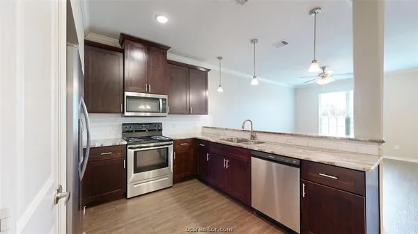 a kitchen with granite countertop stainless steel appliances and wooden cabinets