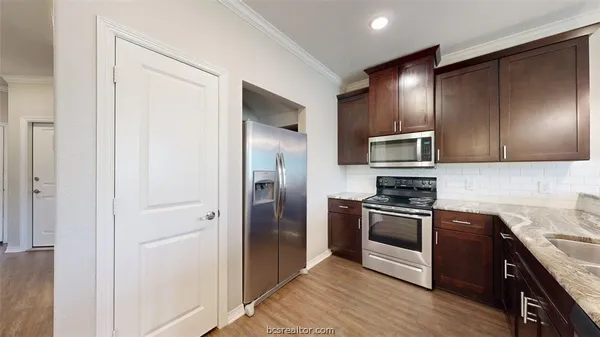a kitchen with stainless steel appliances granite countertop a refrigerator and a sink