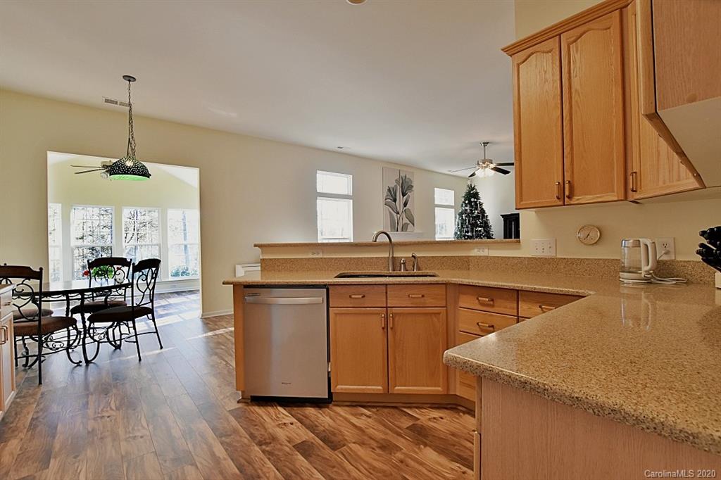 1132 Gower Street Fort Mill, SC 29708 - Photo 10 of 27 a kitchen with a stove a sink a dining table and chairs