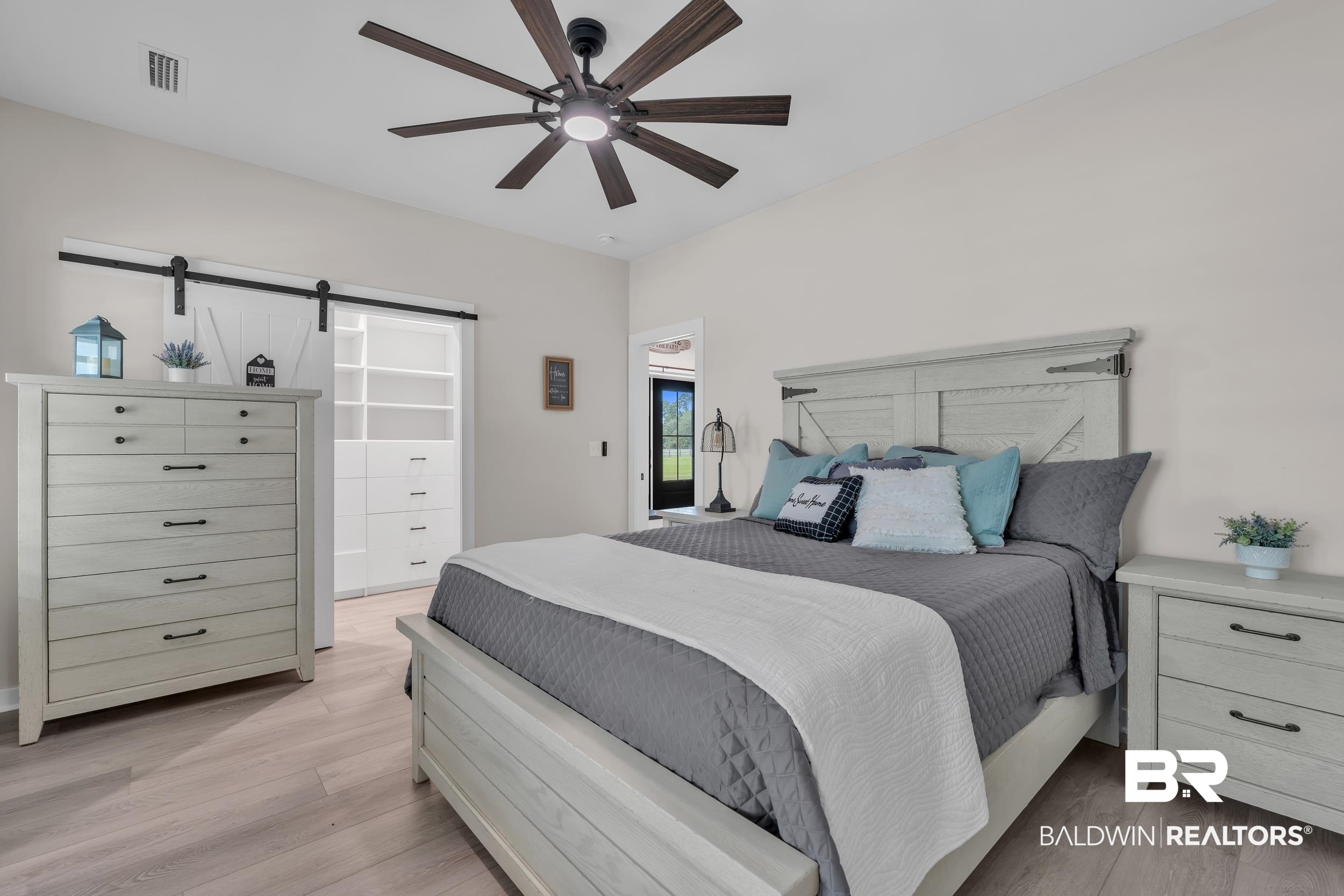 22592 Pastoral Lane Foley, AL 36535 - Photo 24 of 45 Bedroom with a barn door, light wood-style flooring, and a ceiling fan