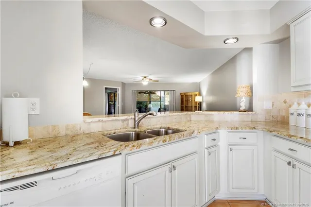 a kitchen with granite countertop a sink and cabinets