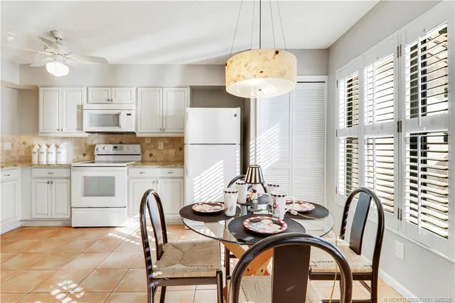 a kitchen with stainless steel appliances a table and chairs
