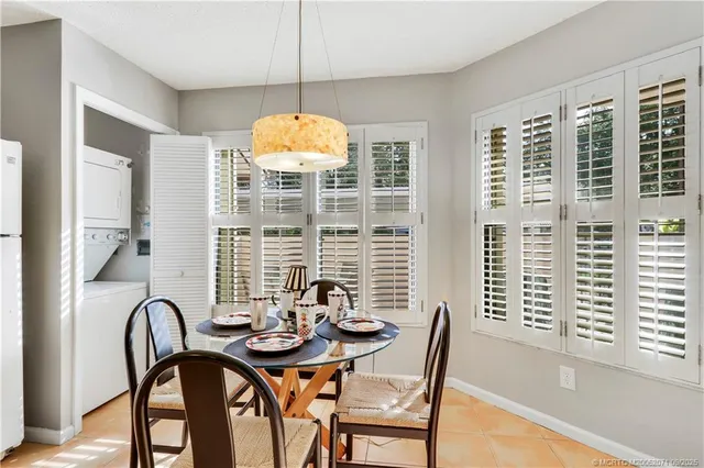 a dining room with furniture a chandelier and window