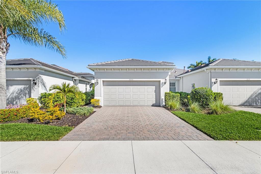 20131 Torch Key Way Estero, FL 33928 - Photo 2 of 47 Prairie-style home featuring stucco siding, decorative driveway, and a tile roof