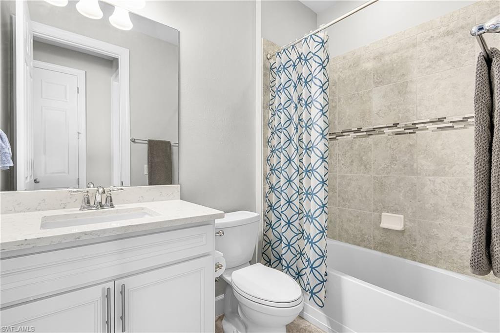 20131 Torch Key Way Estero, FL 33928 - Photo 23 of 47 Bathroom with shower / tub combo with curtain and vanity