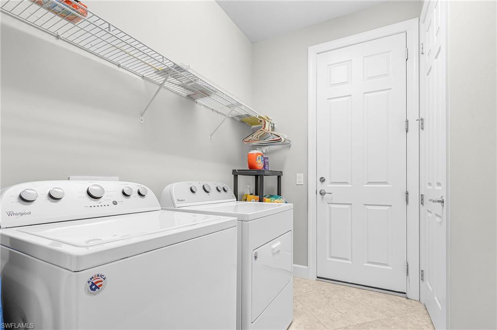 20131 Torch Key Way Estero, FL 33928 - Photo 28 of 47 Laundry area with washing machine and dryer and light tile patterned floors