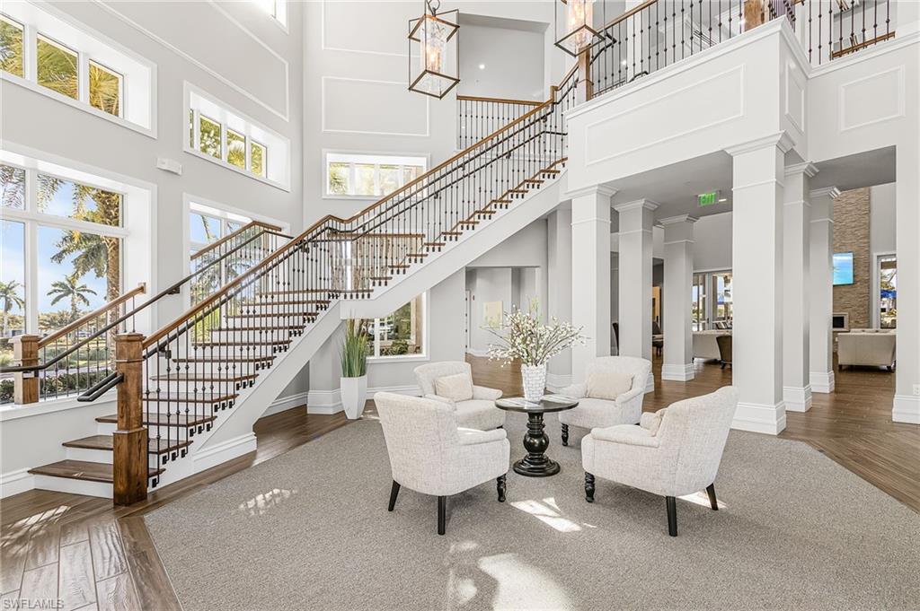 20131 Torch Key Way Estero, FL 33928 - Photo 29 of 47 Living room featuring decorative columns, hardwood / wood-style floors, healthy amount of natural light, and a high ceiling