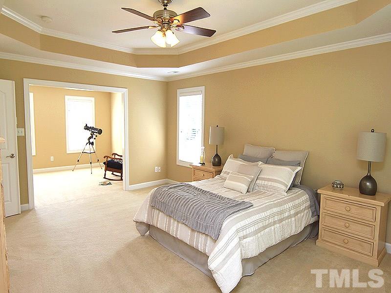 9223 Stone Mountain Road Raleigh, NC 27613 - Photo 11 of 17 a bedroom with a bed and a chandelier