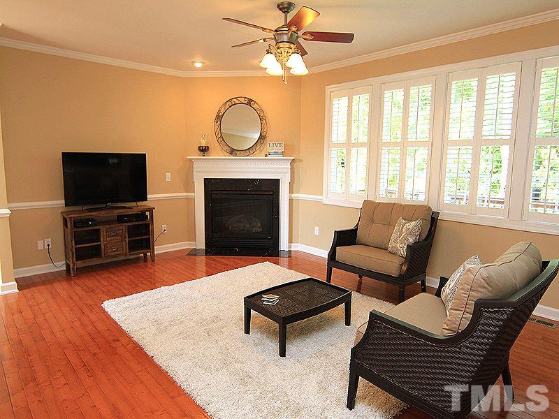 9223 Stone Mountain Road Raleigh, NC 27613 - Photo 5 of 17 a living room with furniture a fireplace and a flat screen tv