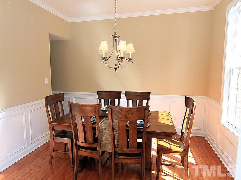9223 Stone Mountain Road Raleigh, NC 27613 - Photo 9 of 17 a view of a dining room with furniture a chandelier and wooden floor