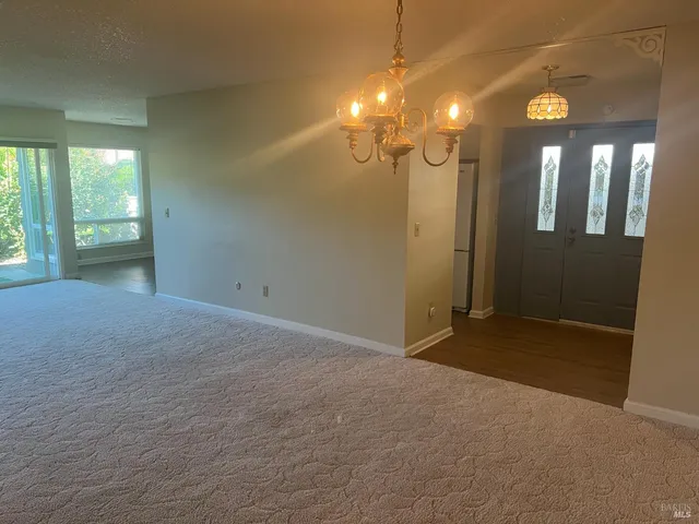 a view of a room with a chandelier fan and windows