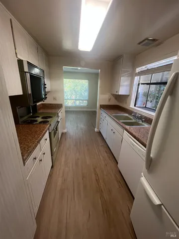 a kitchen with stainless steel appliances a stove a sink and a refrigerator