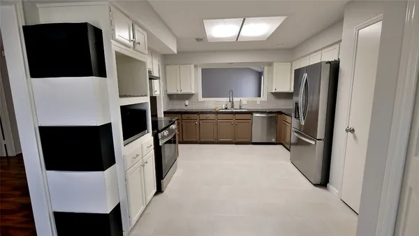 a large kitchen with a stove a refrigerator and a fireplace