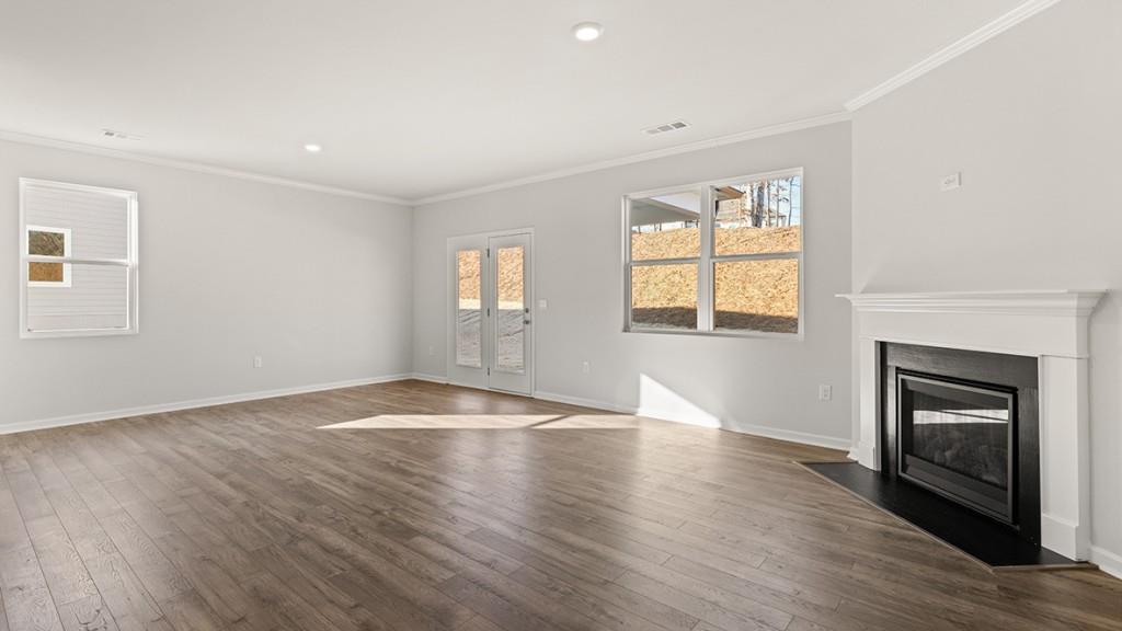 4083 Peregrine Way Gainesville, GA 30506 - Photo 11 of 34 an empty room with wooden floor fireplace and windows
