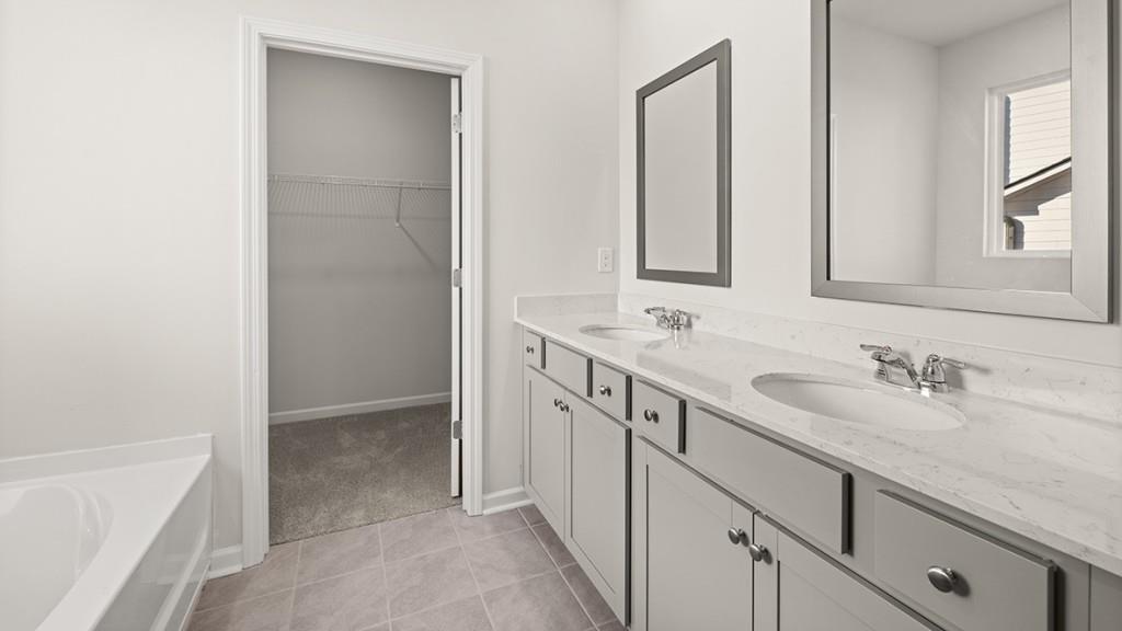 4083 Peregrine Way Gainesville, GA 30506 - Photo 18 of 34 a bathroom with a double vanity sink a mirror and a bathtub