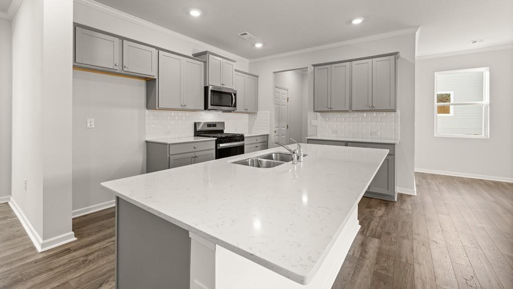 4083 Peregrine Way Gainesville, GA 30506 - Photo 6 of 34 a kitchen with stainless steel appliances a microwave oven a sink dishwasher and wooden floor
