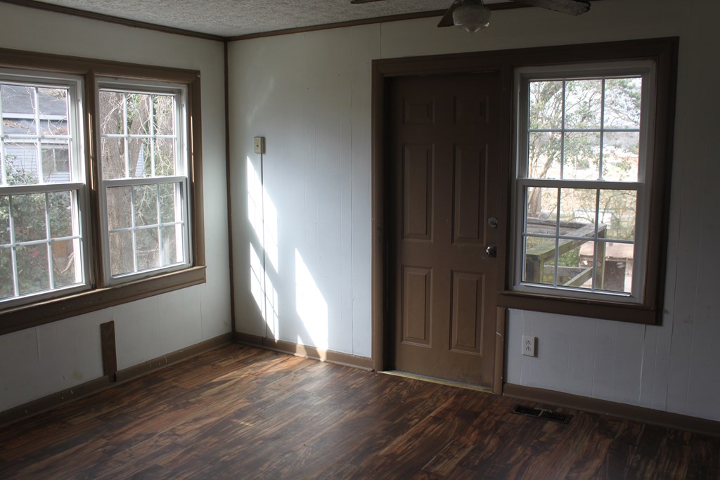 2 Wilson Street Manchester, GA 31816 - Photo 5 of 18 an empty room with wooden floor and windows
