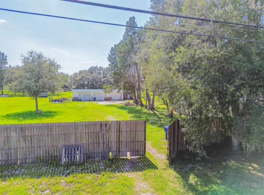12321 Shady Hills Road Spring Hill, FL 34610 - Photo 23 of 30 a house view with a swimming pool and a yard