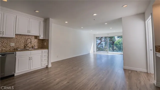 a view of a kitchen with wooden floor and electronic appliances