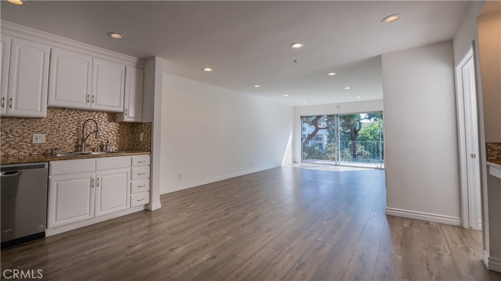 a view of a kitchen with wooden floor and electronic appliances