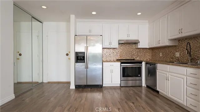 a kitchen with stainless steel appliances granite countertop a refrigerator and a stove top oven