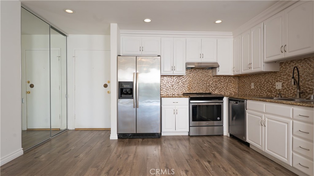 102 Scholz Plaza, Unit 37 Newport Beach, CA 92663 - Photo 2 of 12 a kitchen with stainless steel appliances granite countertop a refrigerator and a stove top oven
