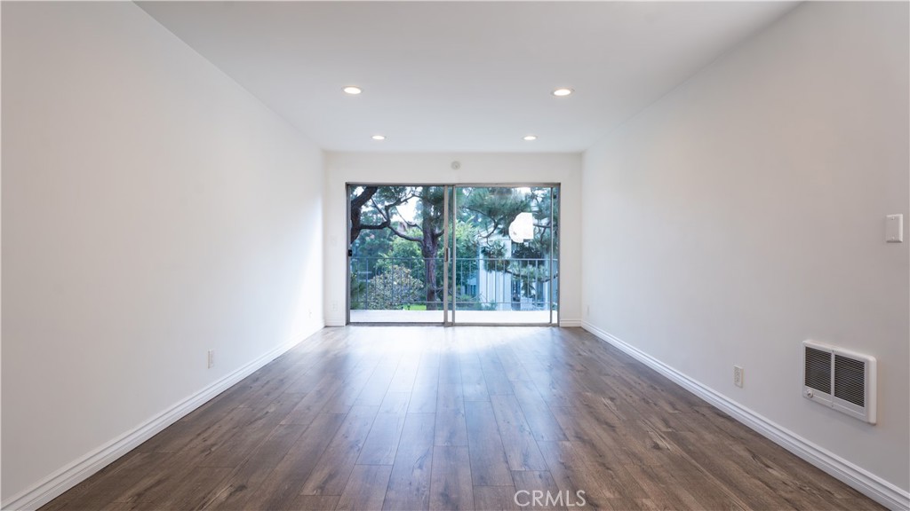 102 Scholz Plaza, Unit 37 Newport Beach, CA 92663 - Photo 4 of 12 wooden floor in an empty room with a window
