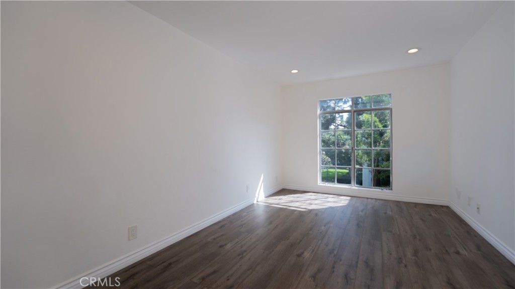 102 Scholz Plaza, Unit 37 Newport Beach, CA 92663 - Photo 9 of 12 a view of an empty room with wooden floor and a window