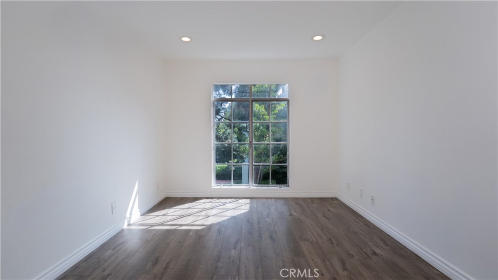 102 Scholz Plaza, Unit 37 Newport Beach, CA 92663 - Photo 10 of 12 a view of an empty room with wooden floor and a window