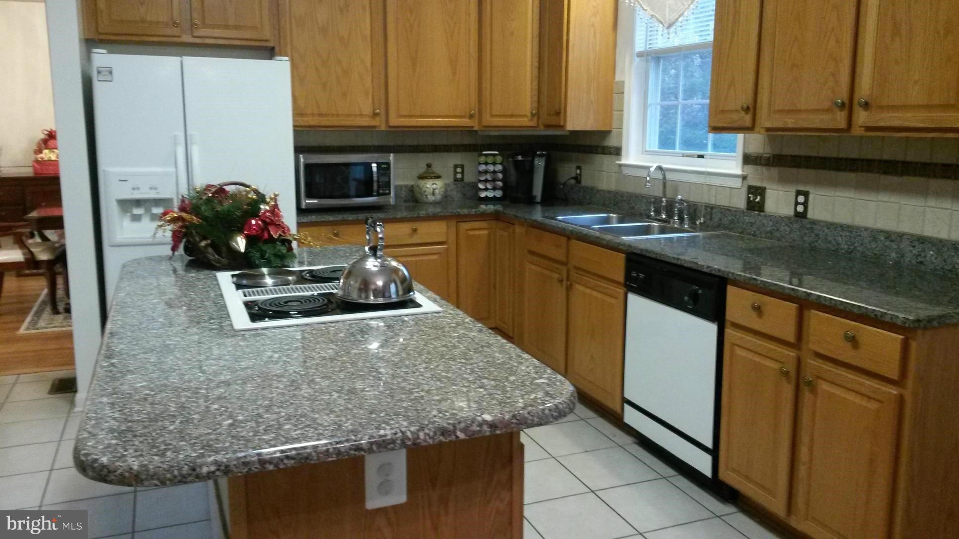 6540 Running Brook Road Manassas, VA 20112 - Photo 3 of 17 a kitchen with granite countertop a sink a stove and cabinets