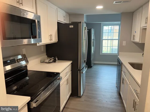 a kitchen with stainless steel appliances a stove a sink a microwave and wooden cabinets