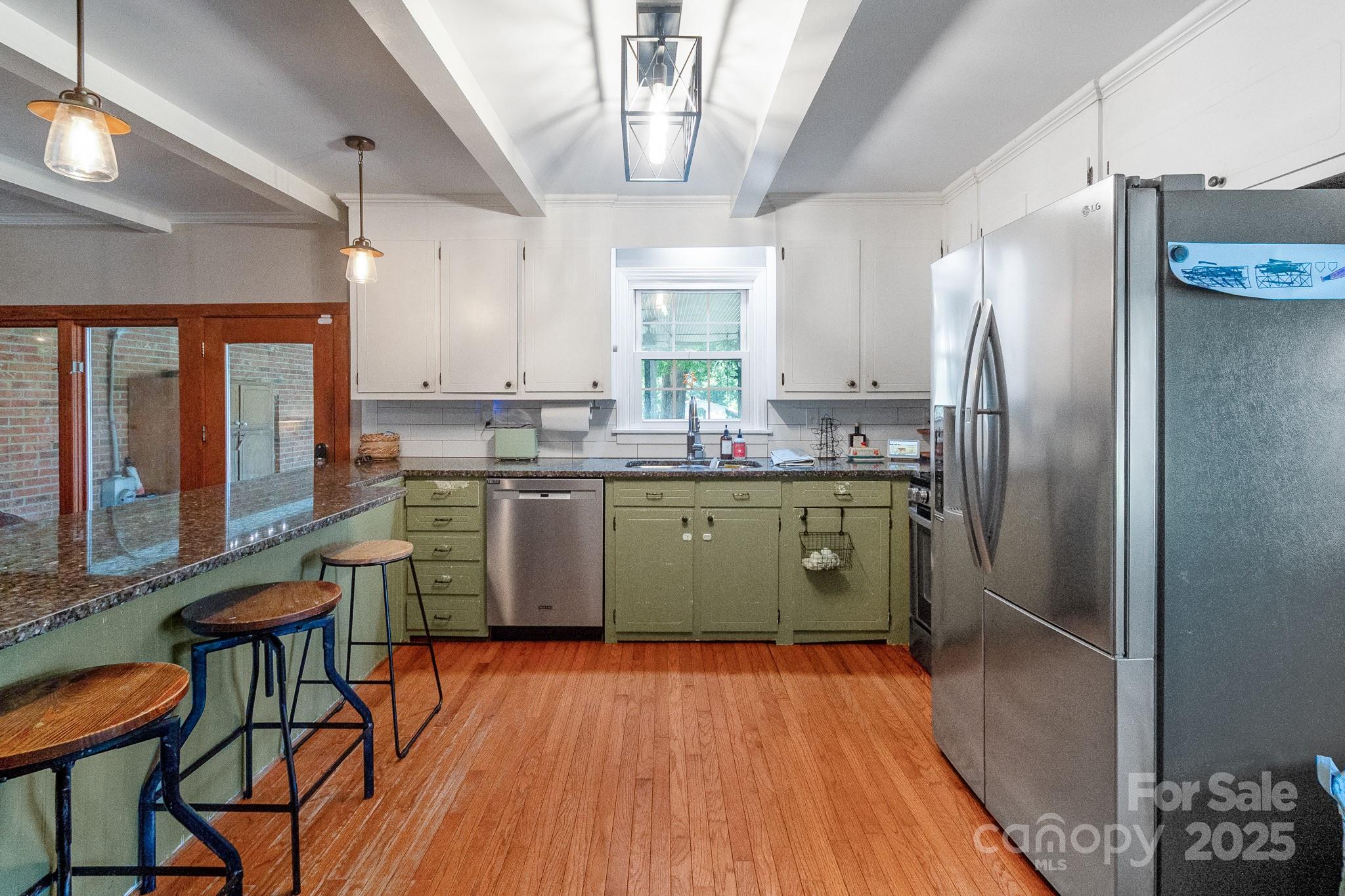 17385 Pond Road Locust, NC 28097 - Photo 13 of 43 a kitchen with stainless steel appliances granite countertop a sink cabinets and wooden floor