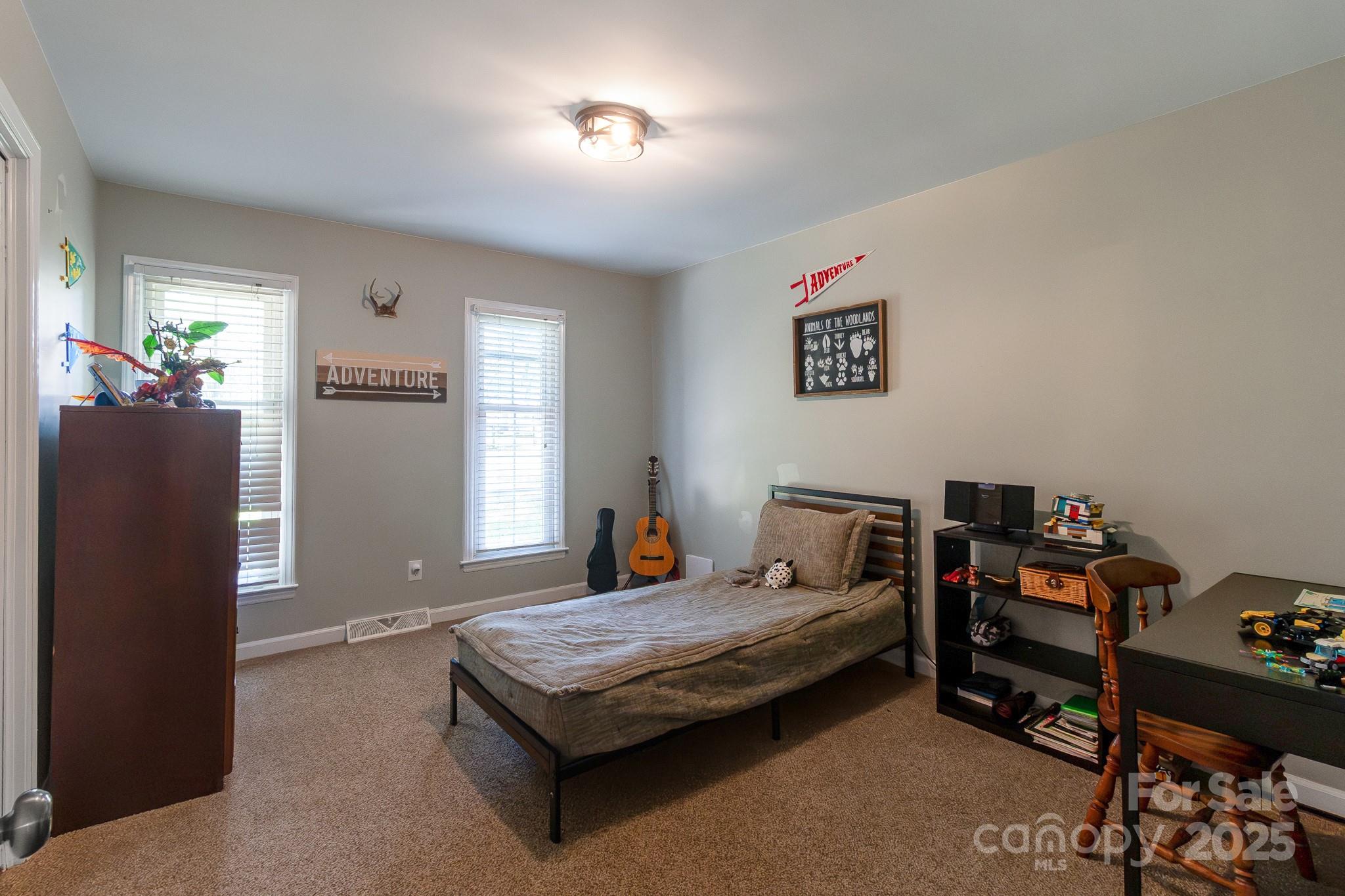 17385 Pond Road Locust, NC 28097 - Photo 24 of 43 a bedroom with a bed and a chandelier