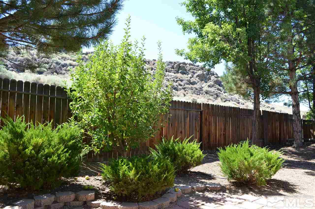 4668 Goodwin Road Sparks, NV 89436 - Photo 3 of 13 a garden with plants and wooden fence