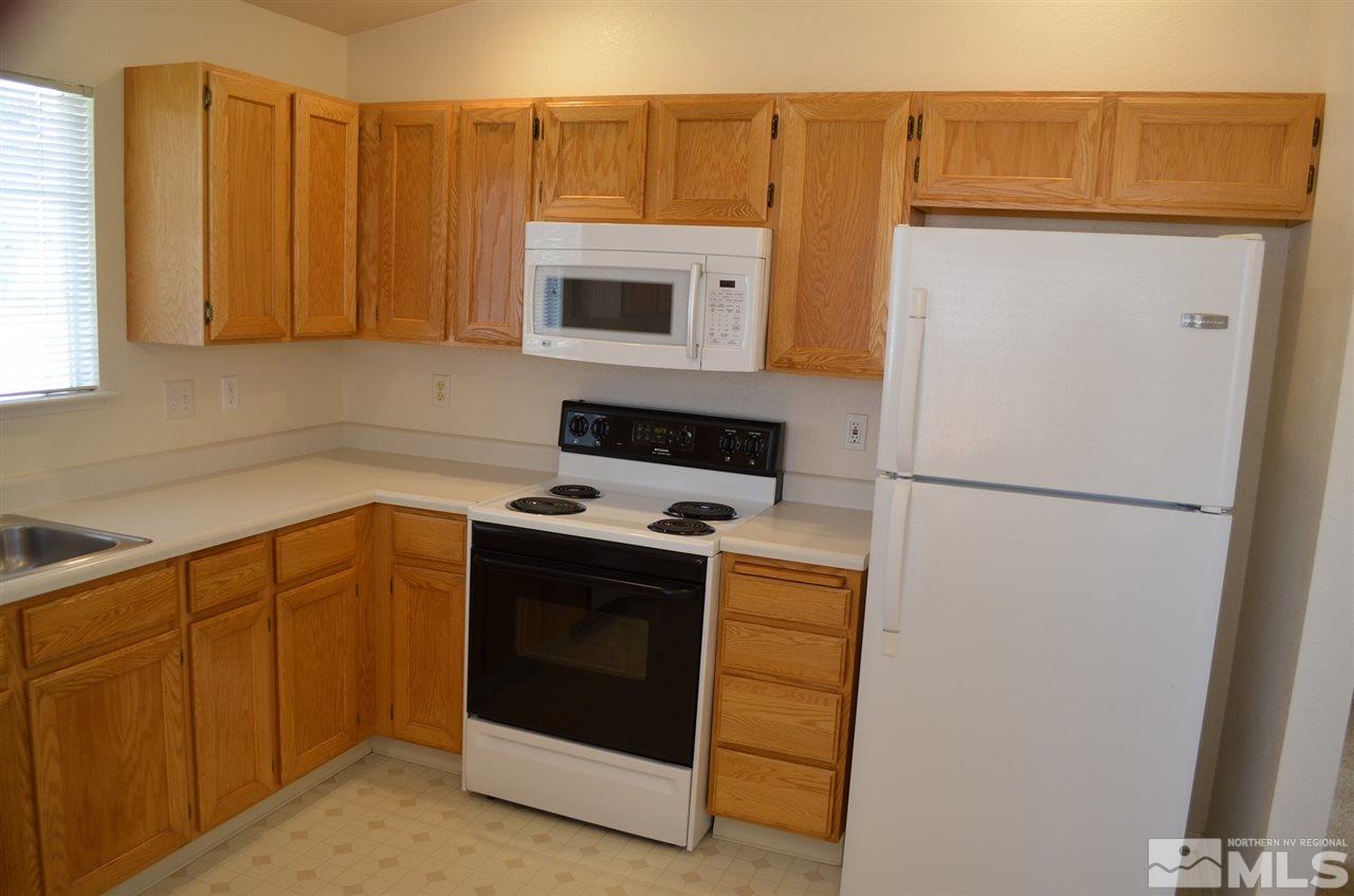 4668 Goodwin Road Sparks, NV 89436 - Photo 7 of 13 a kitchen with stainless steel appliances granite countertop a refrigerator a stove and a sink