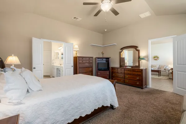 a spacious bedroom with a bed and dresser