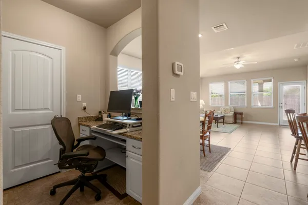 a view of a workspace with furniture and a window