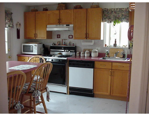 48 Fowler Road Lowell, MA 01854 - Photo 3 of 11 a kitchen with a stove a sink cabinets and a dining table