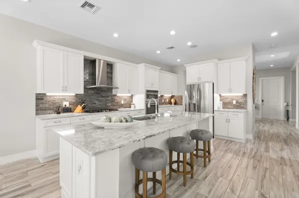 a kitchen with a refrigerator a stove a sink dishwasher with a dining table and chairs