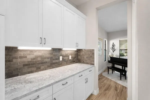 a spacious bathroom with a granite countertop sink a mirror and bathtub