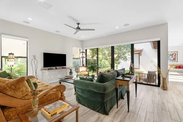 a living room with furniture a flat screen tv and a large window