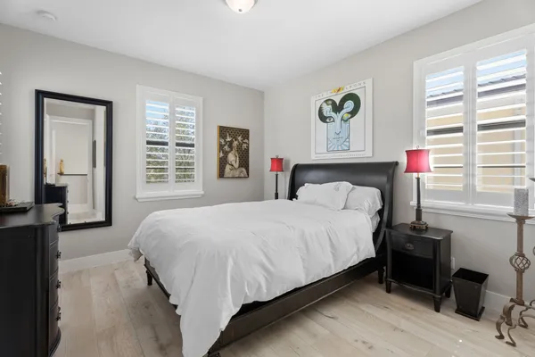 a bedroom with a bed and wooden floor