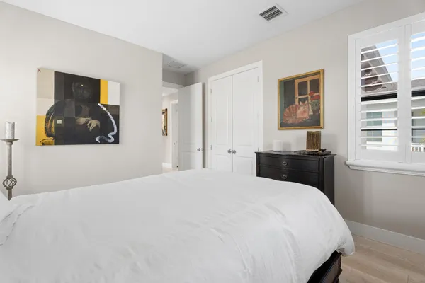 a bedroom with a large bed and wooden floor