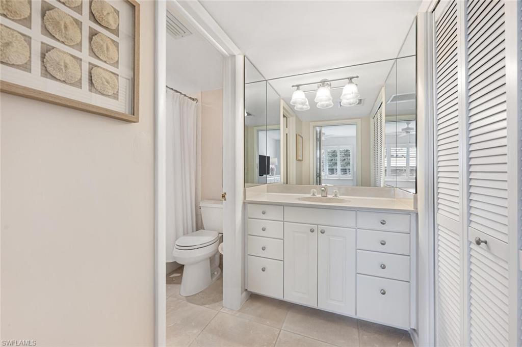 333 4th Avenue South, Unit 202 Naples, FL 34102 - Photo 11 of 16 a bathroom with a granite countertop sink mirror and toilet