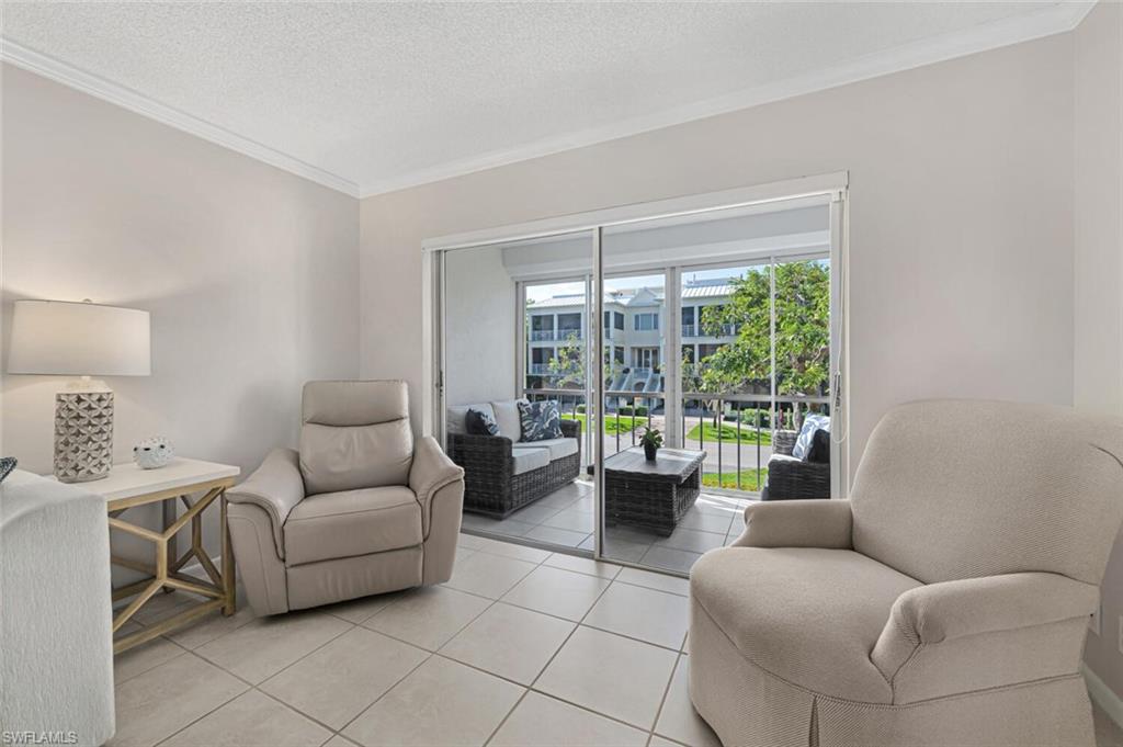 333 4th Avenue South, Unit 202 Naples, FL 34102 - Photo 8 of 16 a living room with furniture and a large window