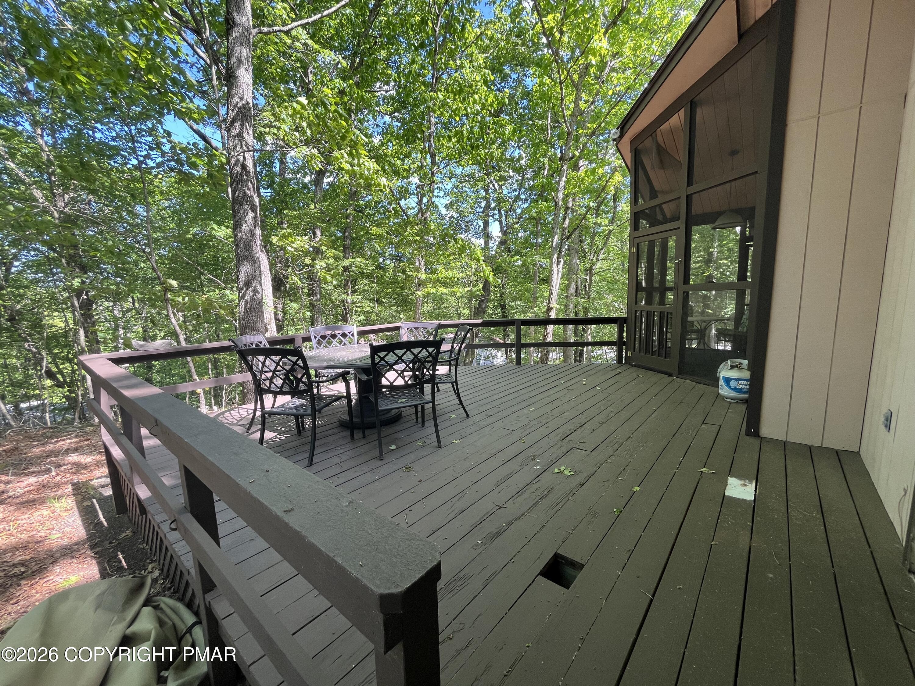 5970 Decker Road Bushkill, PA 18324 - Photo 7 of 26 a view of a roof deck with table and chairs and wooden floor