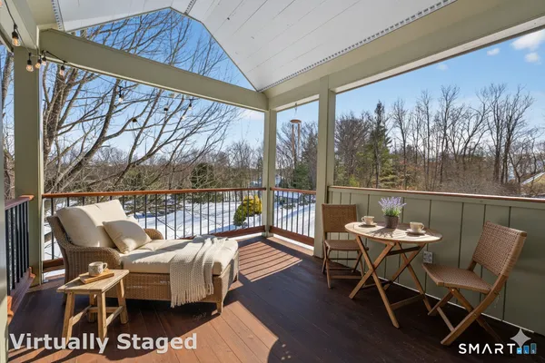 a balcony with wooden floor and outdoor seating
